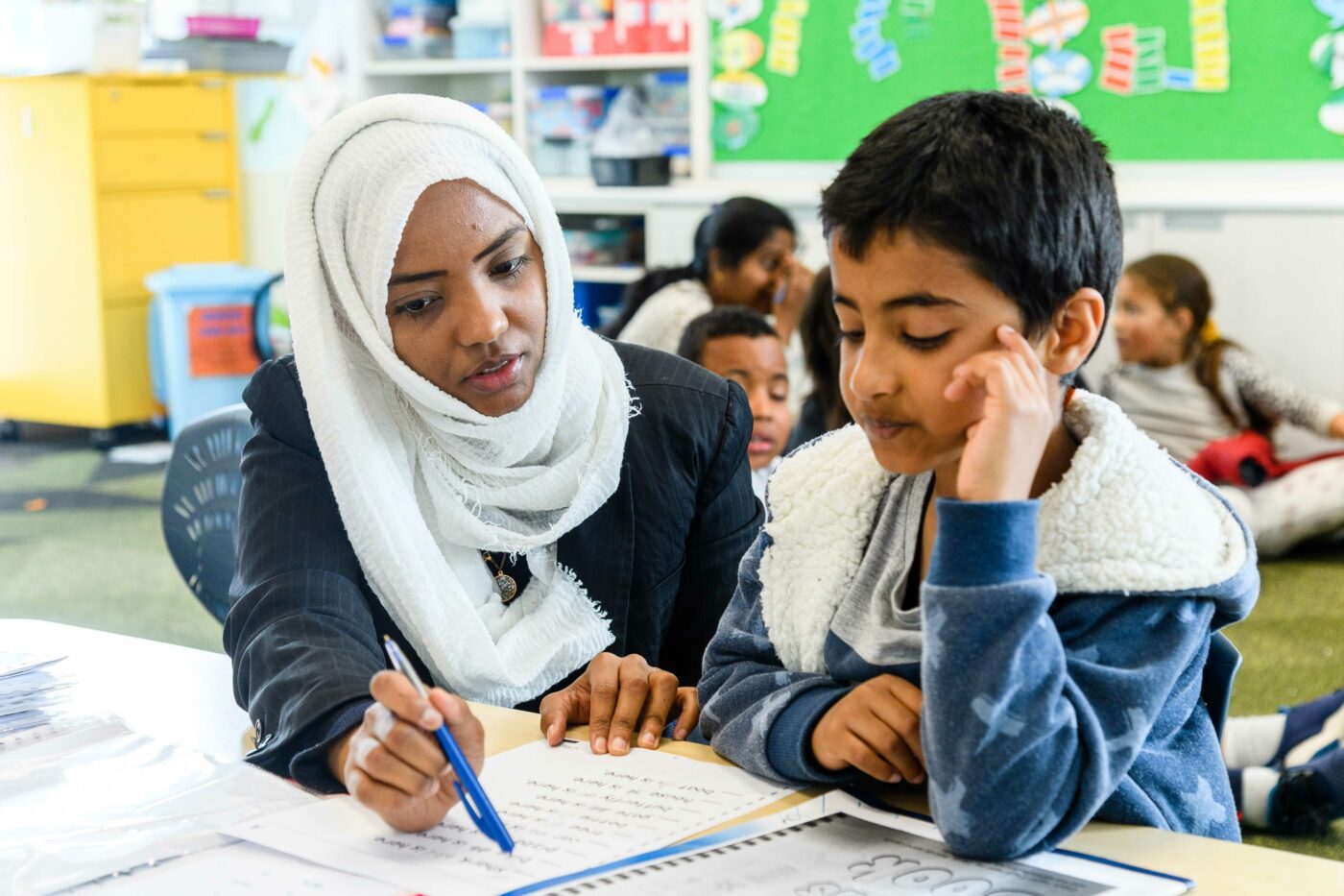 Teacher Aide assists a student with their school work.